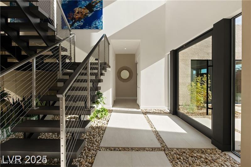 Image 4: Stairs featuring inlaid floor details, a high ceil