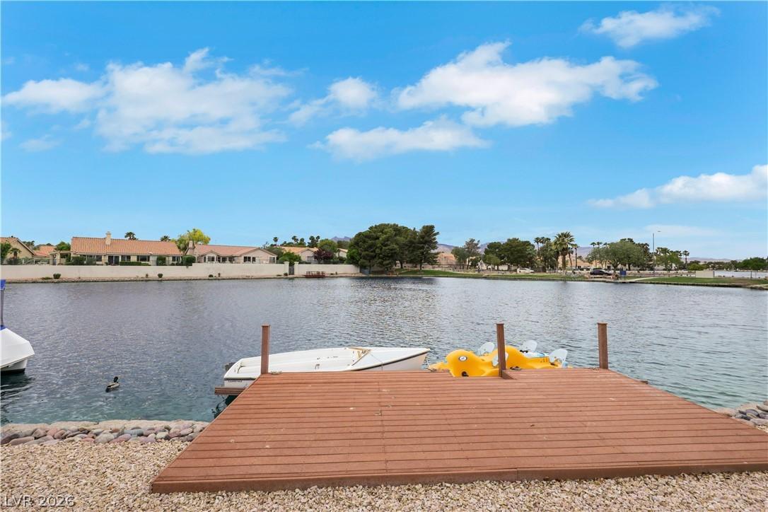 Image 3: A private boat dock extends onto a shimmering lake