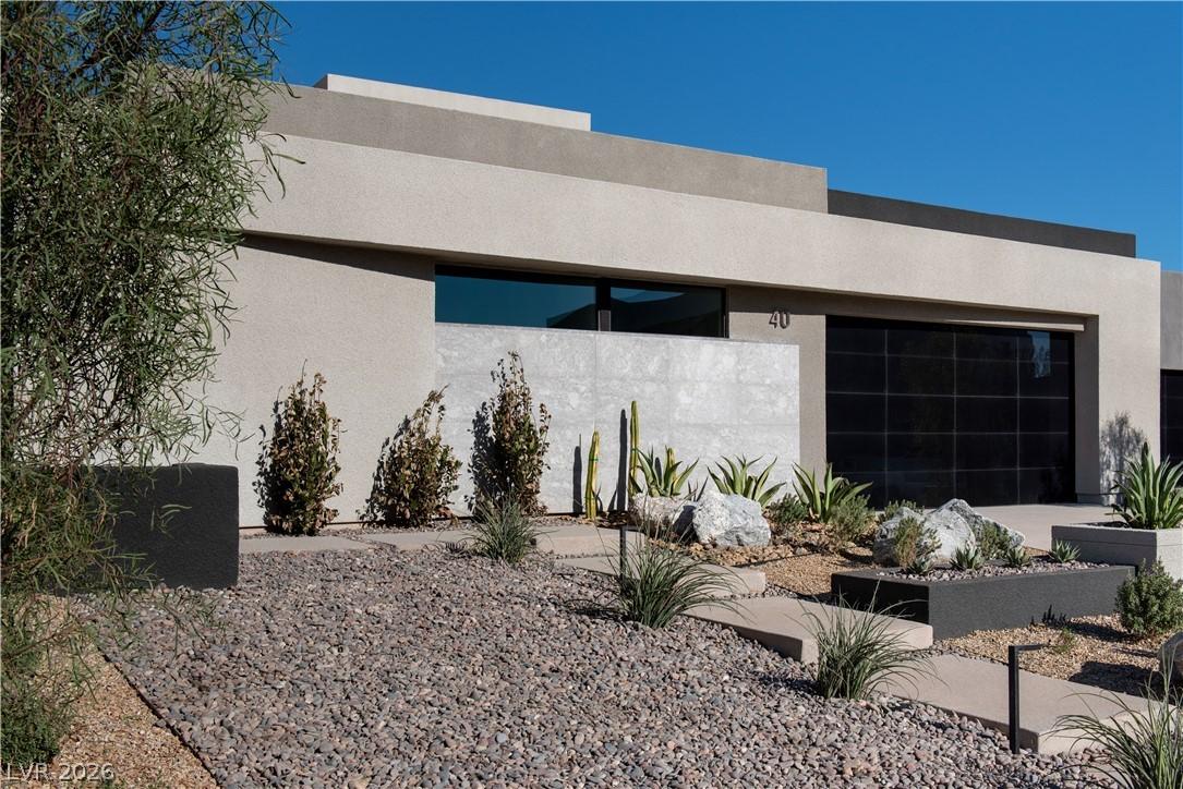 Image 2: Modern desert landscaping surrounds the smooth fac