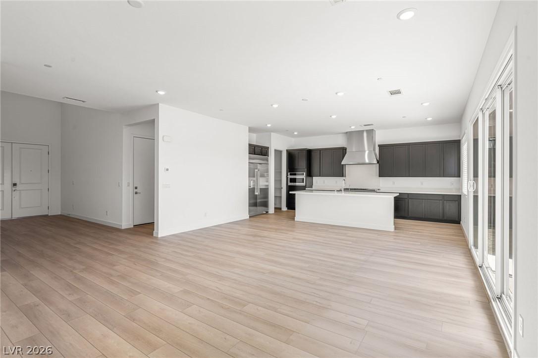Image 4: An open-concept living space with sleek kitchen ca