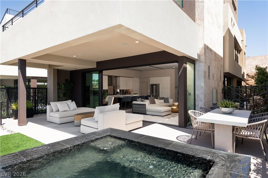 Image 1: An inviting covered patio with a spa offers seamle