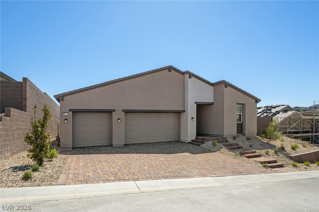 Image 2: Modern desert architecture with a paver driveway,