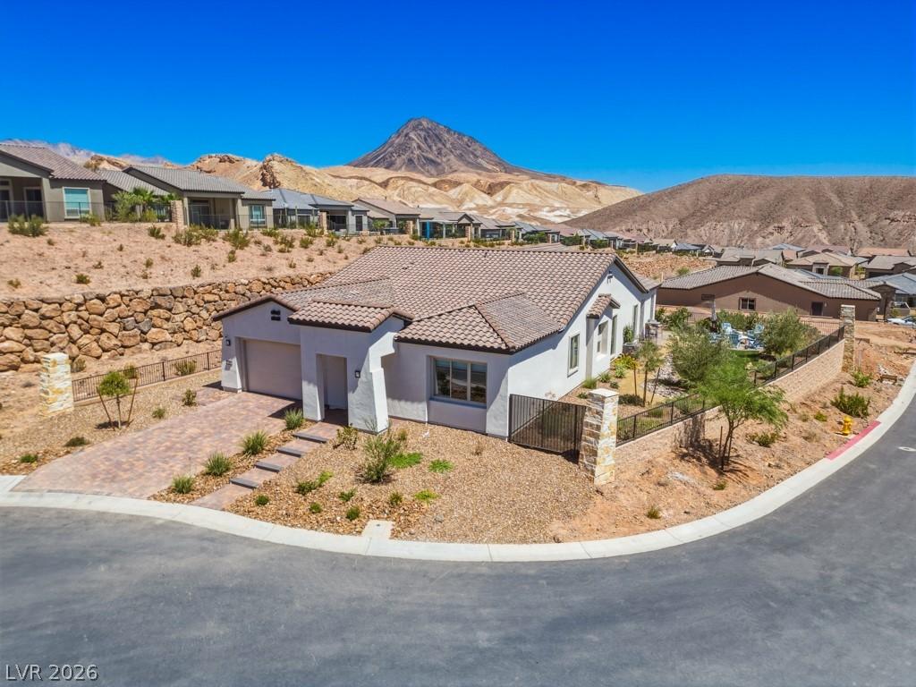 Image 2: A well-maintained desert home with a paver drivewa