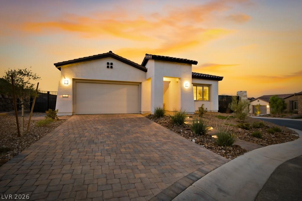 Image 3: A striking modern stucco residence with a paved dr