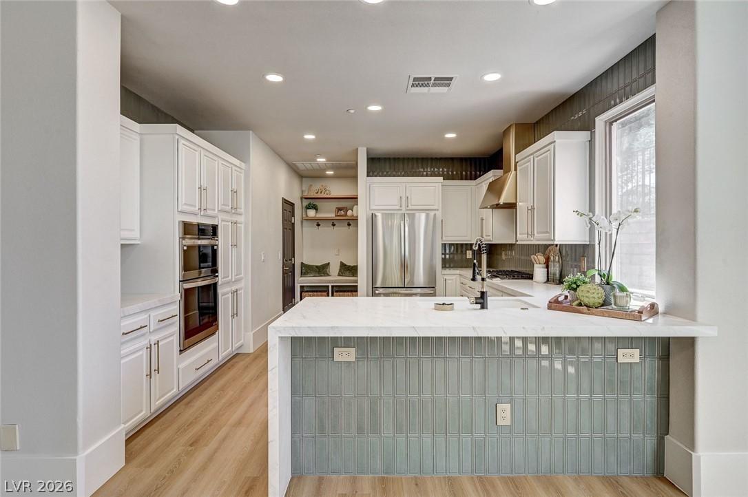 Image 1: A contemporary kitchen features bright white cabin