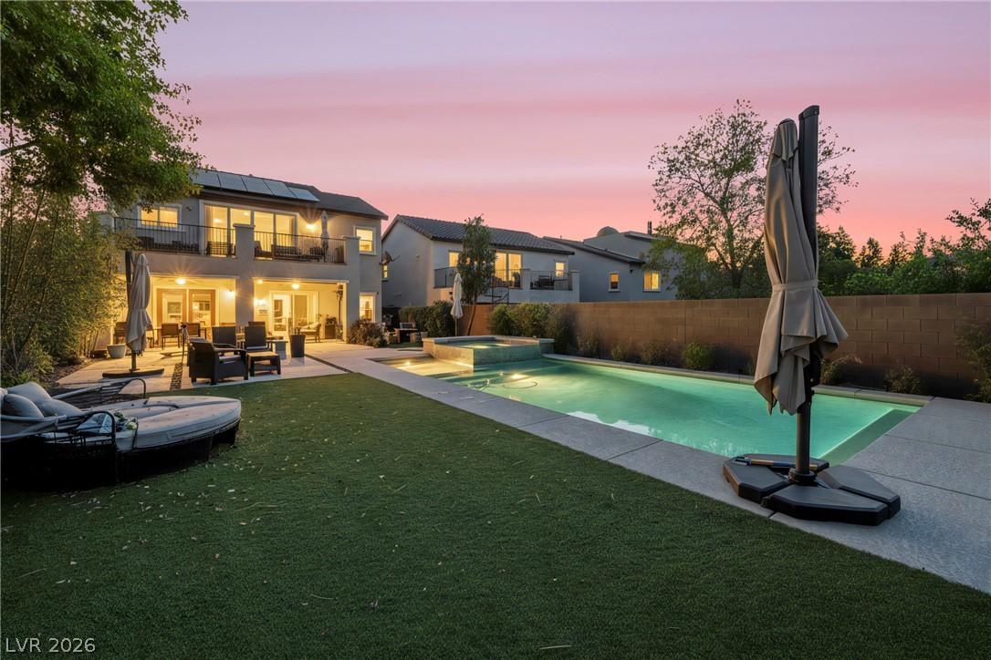 Image 2: A private backyard oasis features a shimmering poo