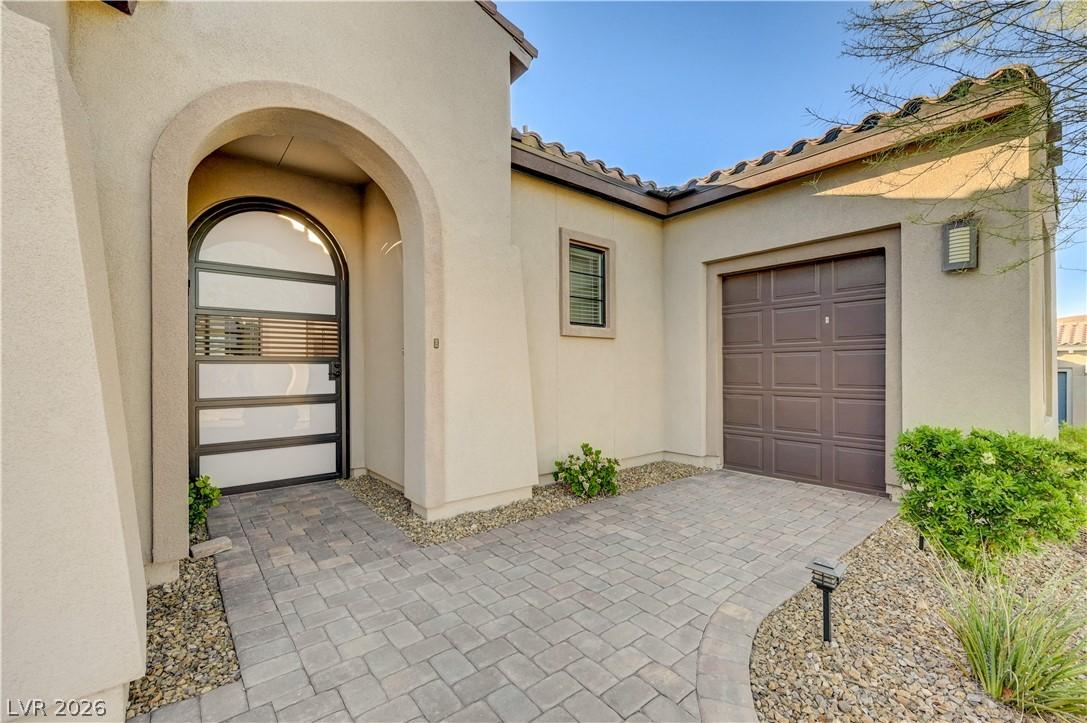 Image 3: View of exterior entry featuring stucco siding and