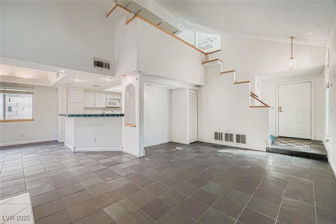 Image 4: Unfurnished living room with high vaulted ceiling