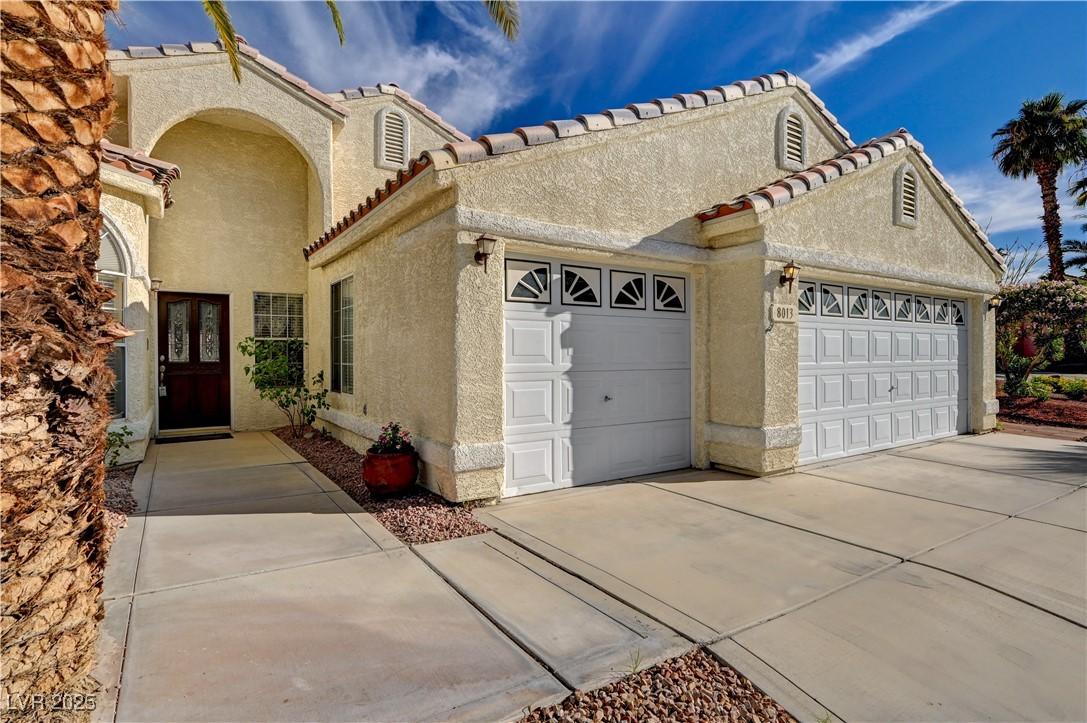 Image 2: View of front facade featuring stucco siding, a ti