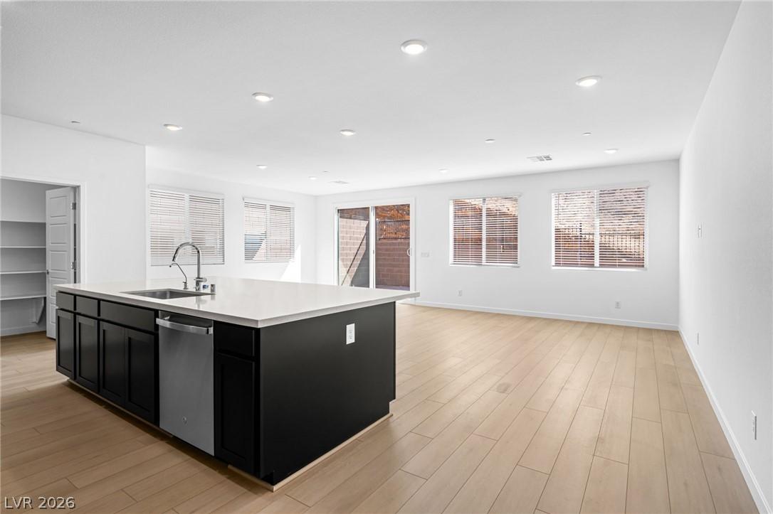 Image 3: A contemporary kitchen island and living space wit