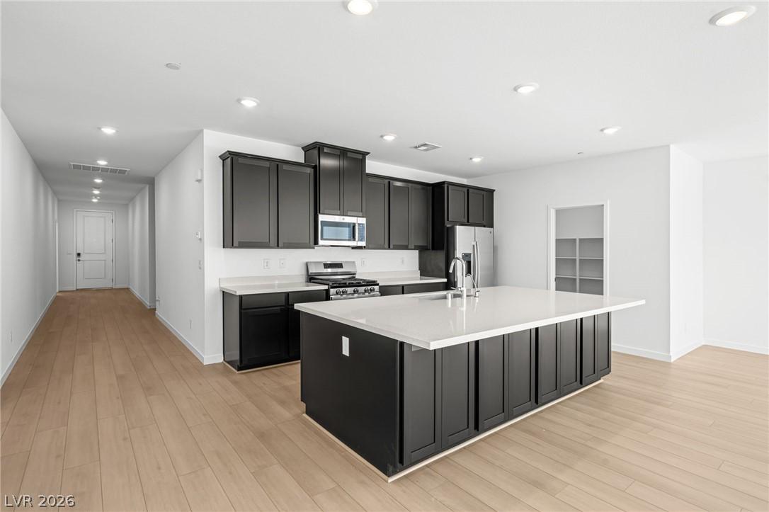 Image 4: An inviting open-concept kitchen features dark cab