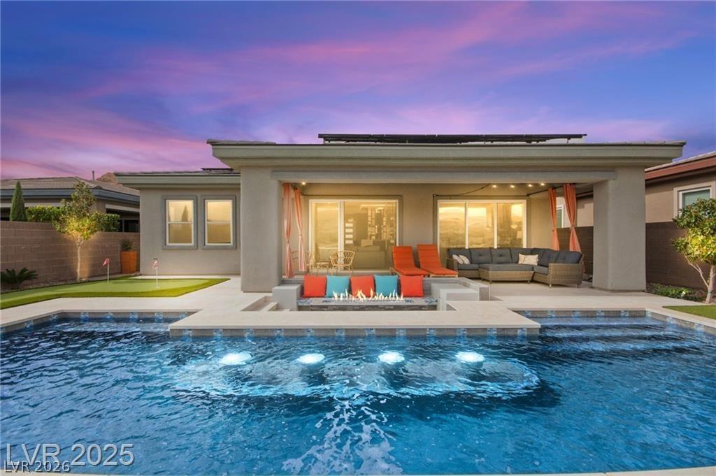Image 2: Back of property at dusk with a fenced backyard, a
