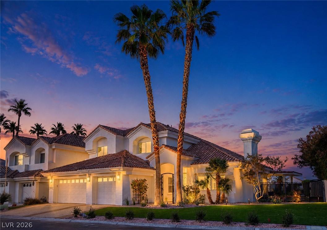 Image 3: Illuminated at twilight, this residence showcases