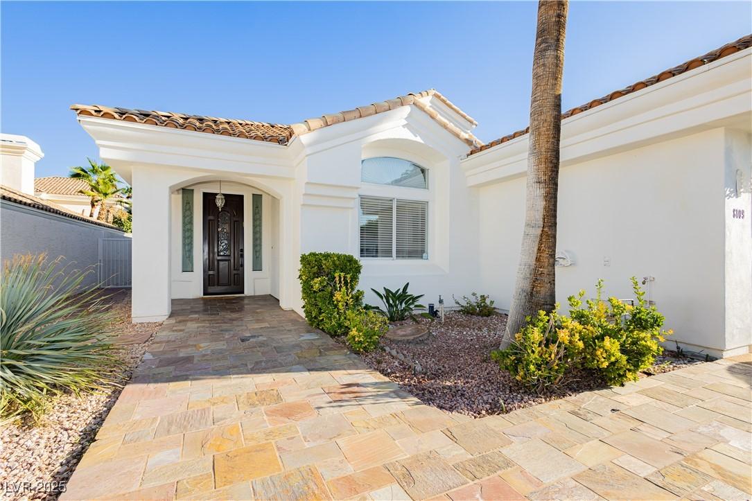 Image 3: Doorway to property with stucco siding and a tile