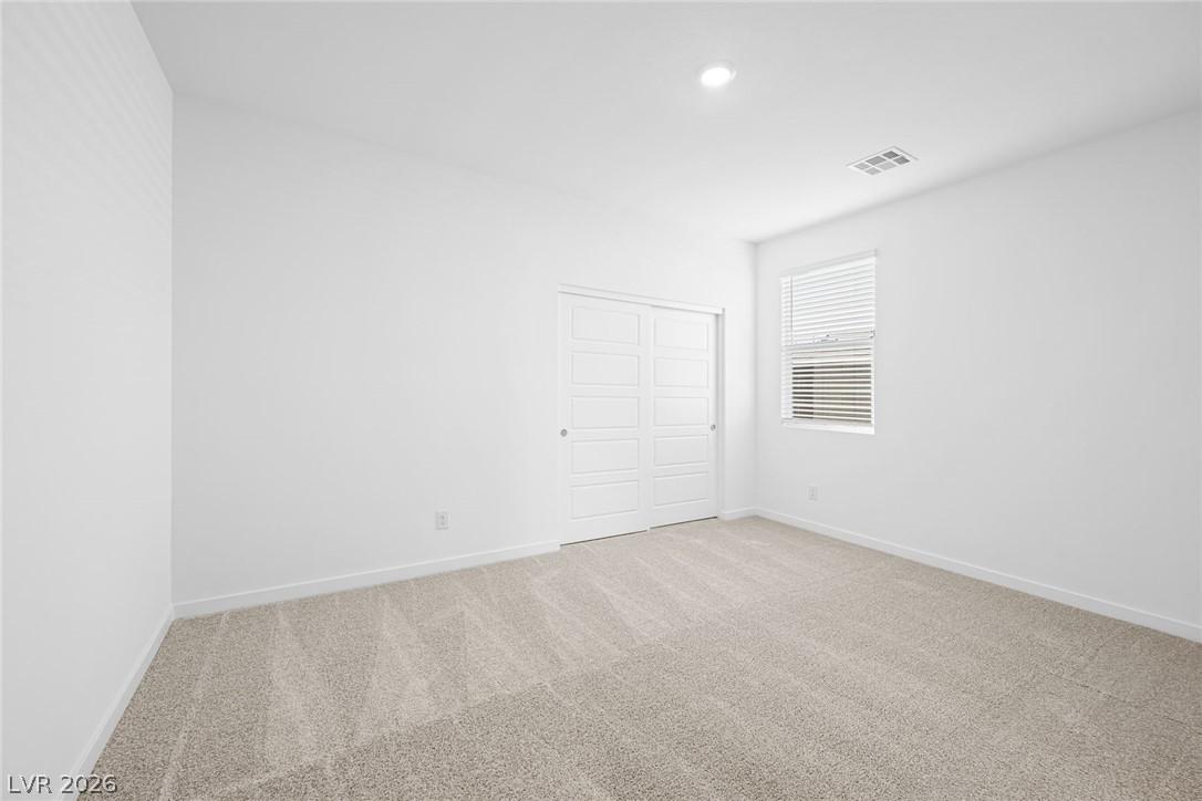 Image 3: A well-lit bedroom offers plush carpeting and conv
