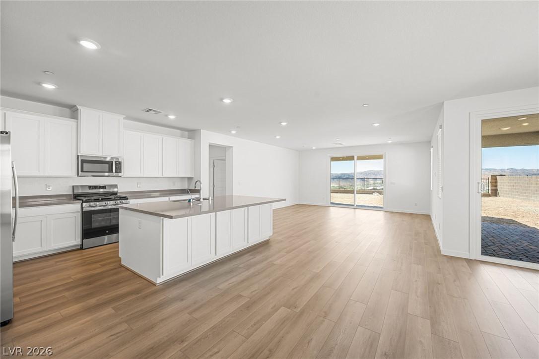 Image 3: An open concept kitchen and living area flows to a