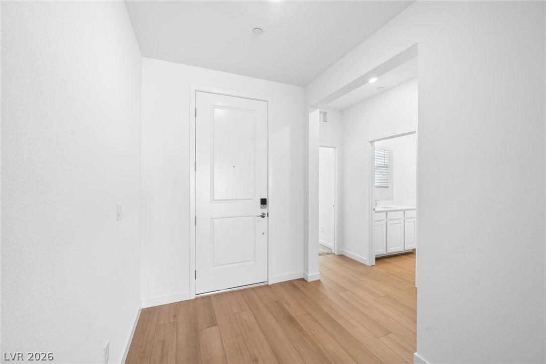 Image 3: A welcoming entry hall with warm wood flooring inv