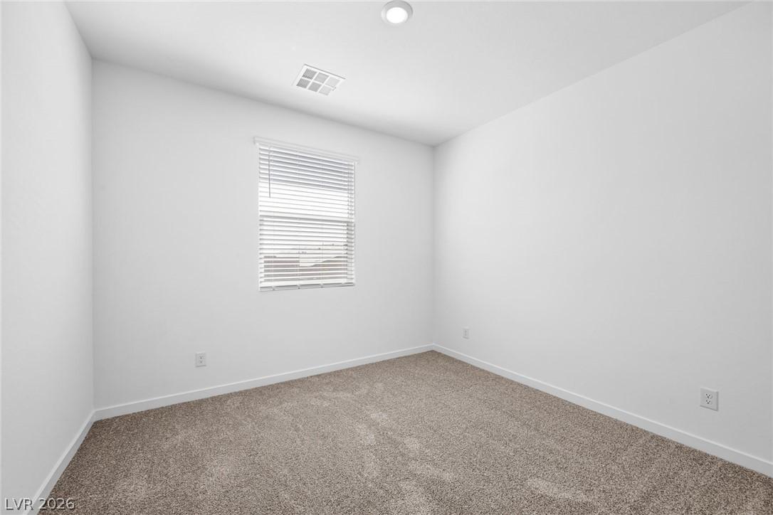 Image 4: A well-lit bedroom features plush carpeting and a
