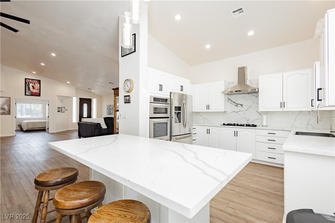 Image 4: Kitchen featuring light stone counters, white cabi