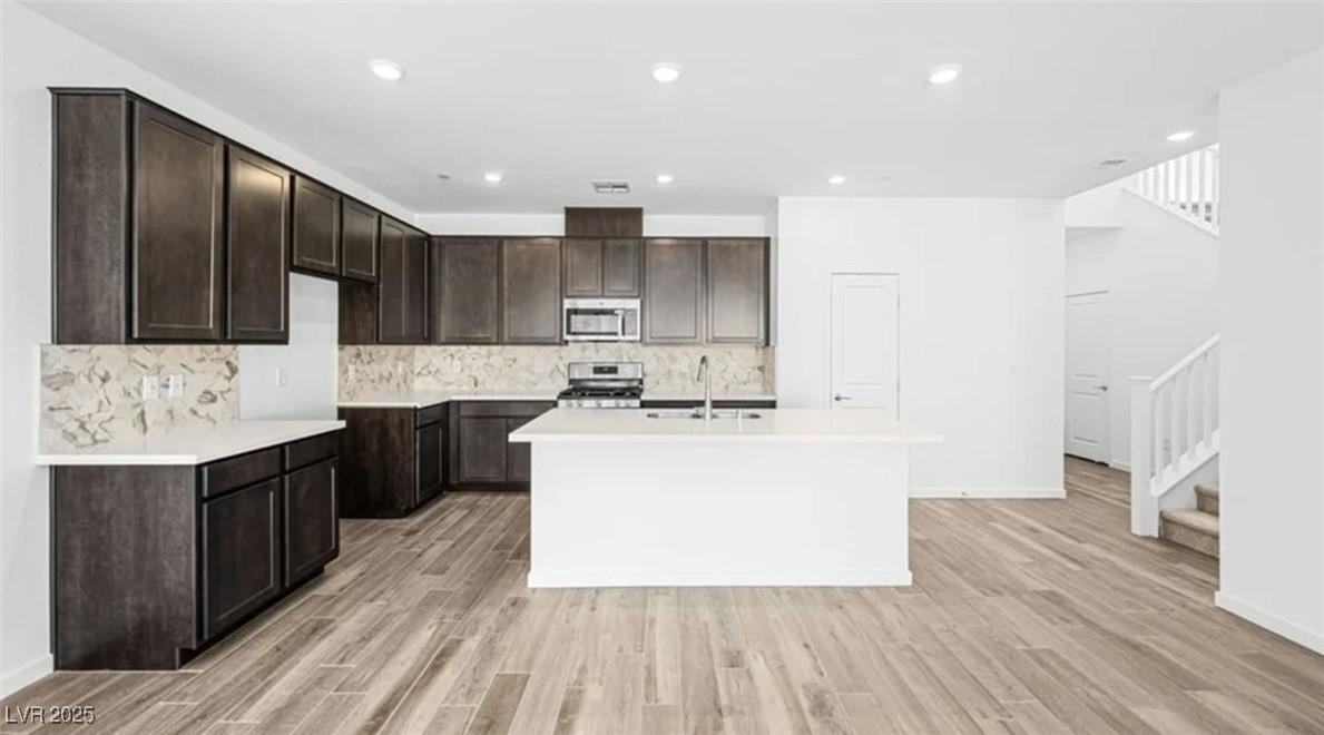 Image 2: Kitchen featuring dark brown cabinetry, a kitchen