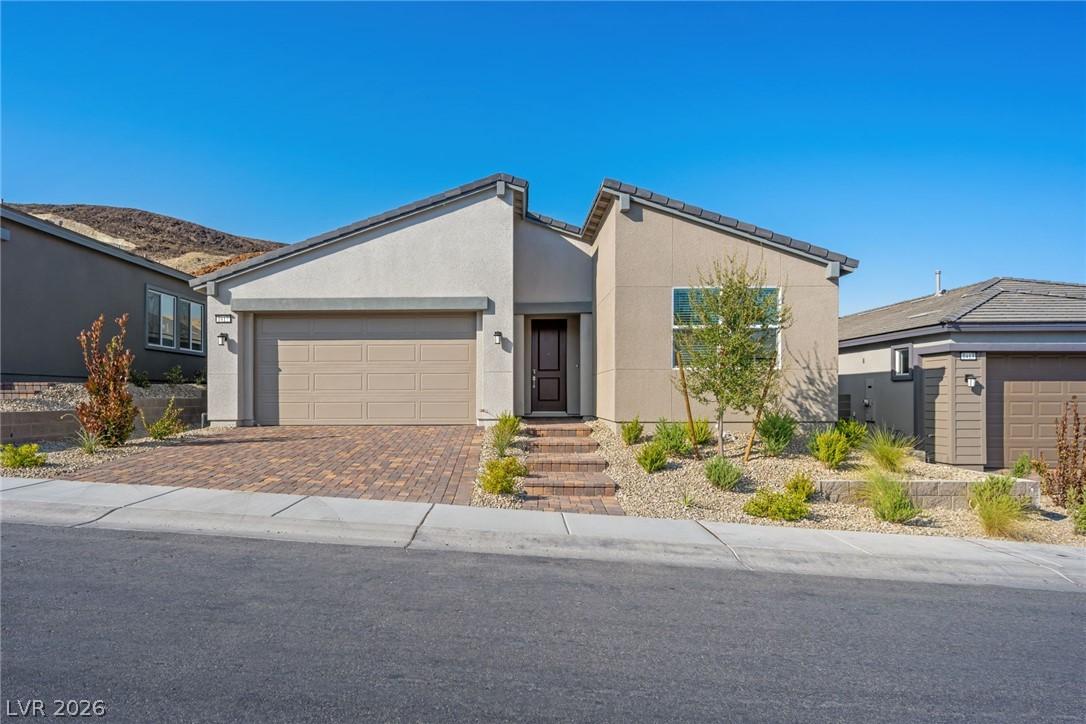 Image 1: A contemporary desert home with a paved driveway a