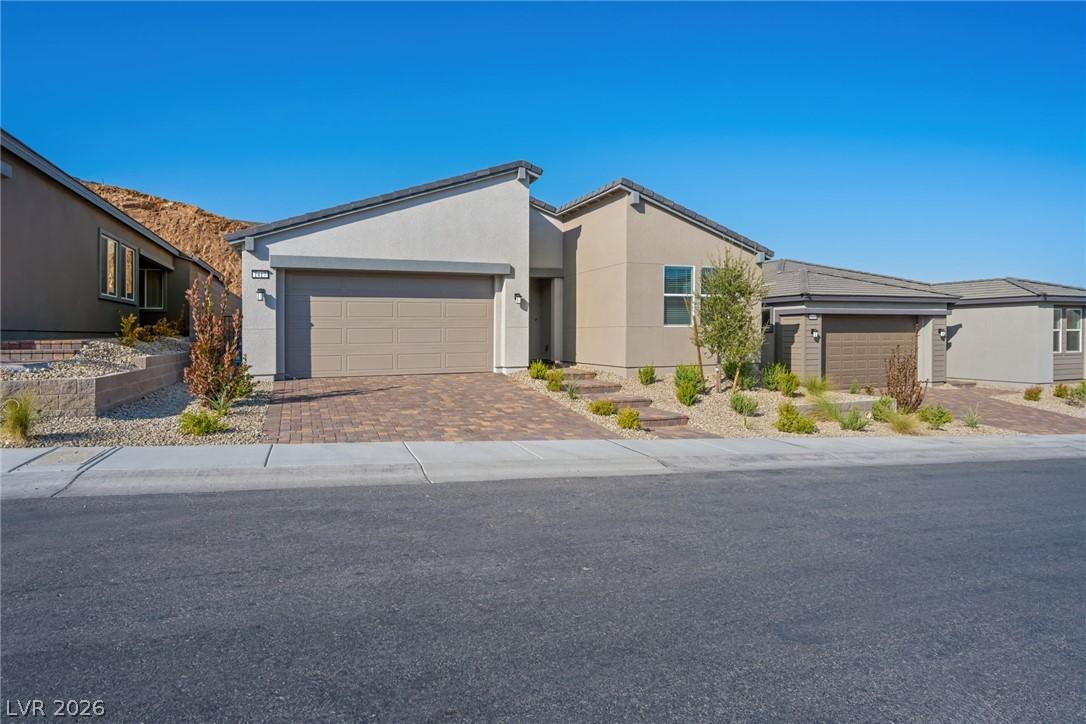 Image 2: A modern facade with a paver driveway leads to thi