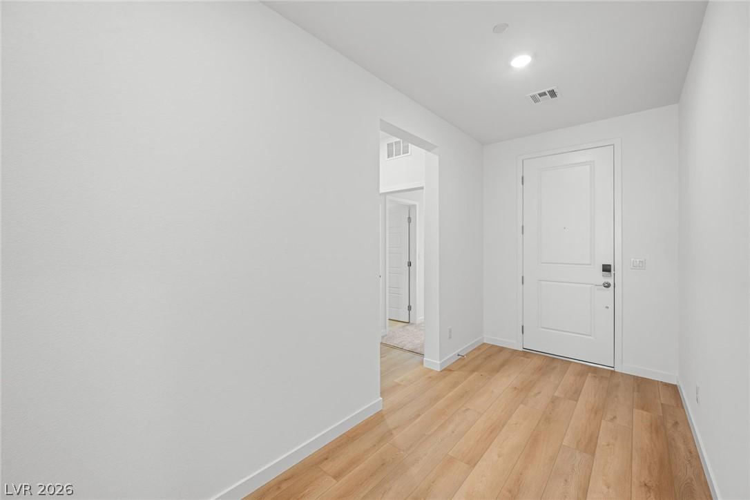 Image 3: A welcoming entryway with warm wood flooring and a
