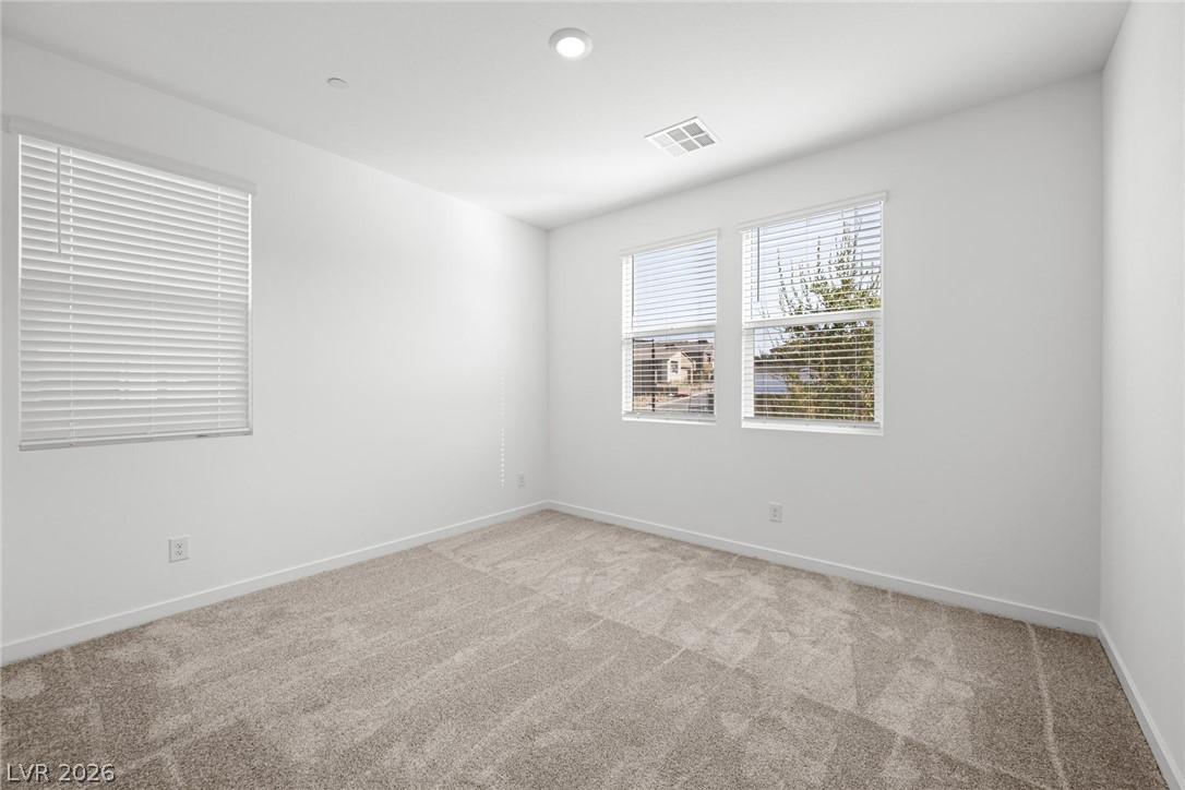Image 4: A quiet secondary bedroom with multiple windows an