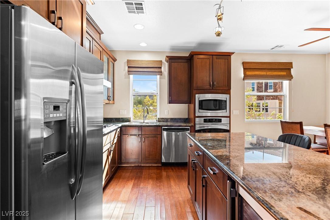 Image 4: A gourmet kitchen boasts granite counters, rich wo