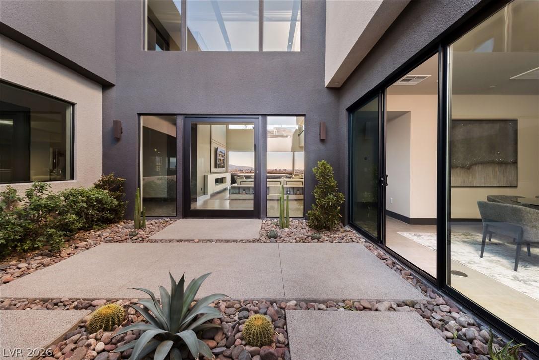 Image 4: A modern facade with expansive glass doors opens t