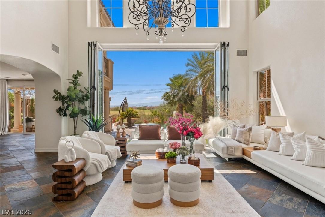 Image 1: An airy living room with soaring ceilings opens to