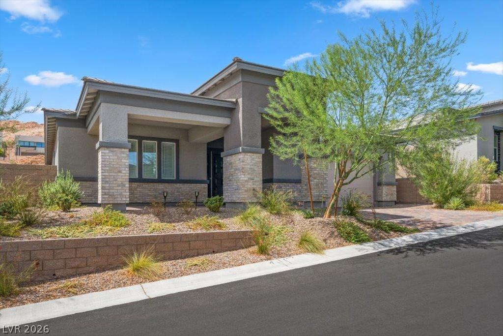 Image 2: Modern desert landscaping frames this welcoming fa