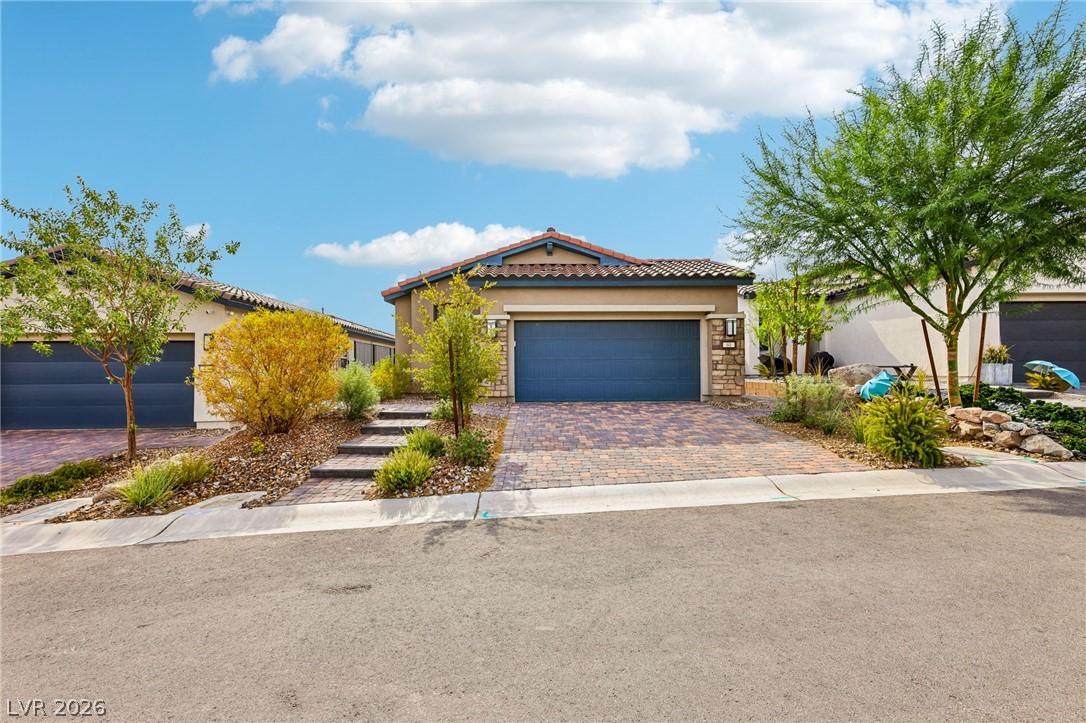 Image 1: A well-manicured front yard with a paver driveway