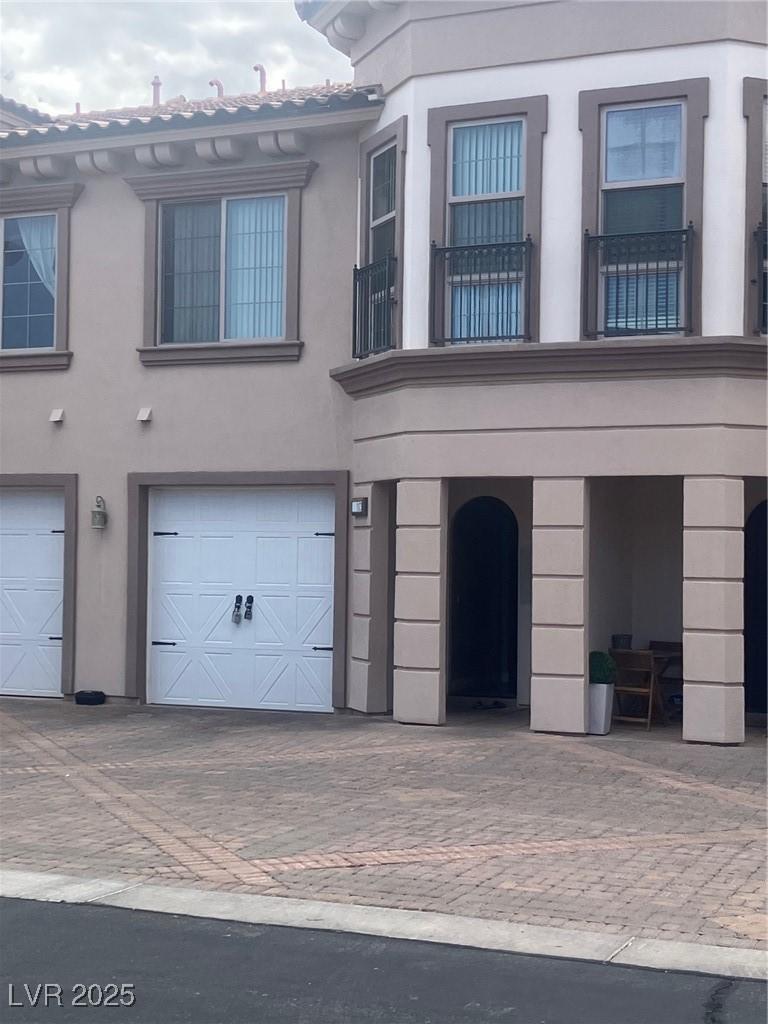 Image 2: View of front facade with a balcony, driveway, stu