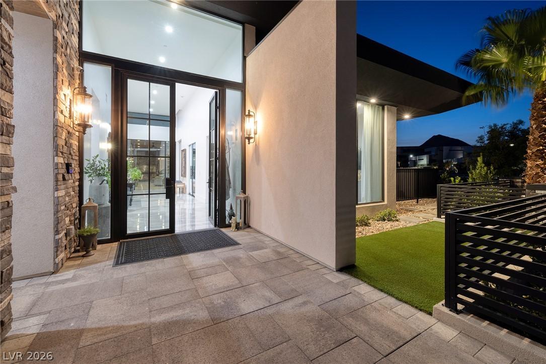 Image 3: A grand entry with a stone facade and expansive gl