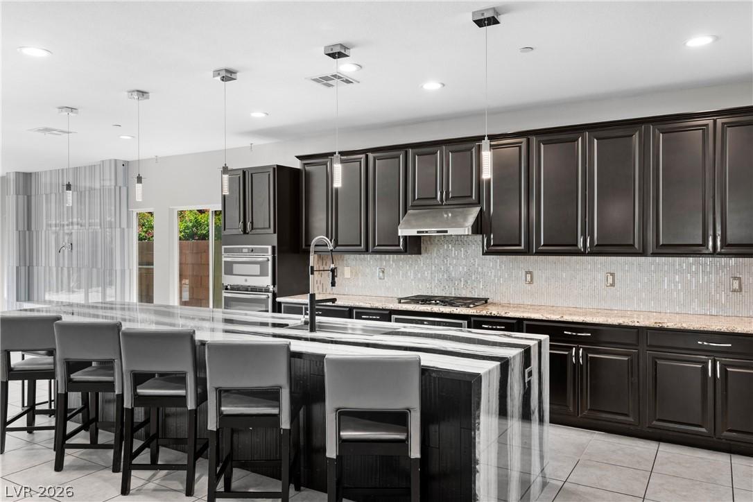 Image 2: This kitchen showcases a central island and sleek