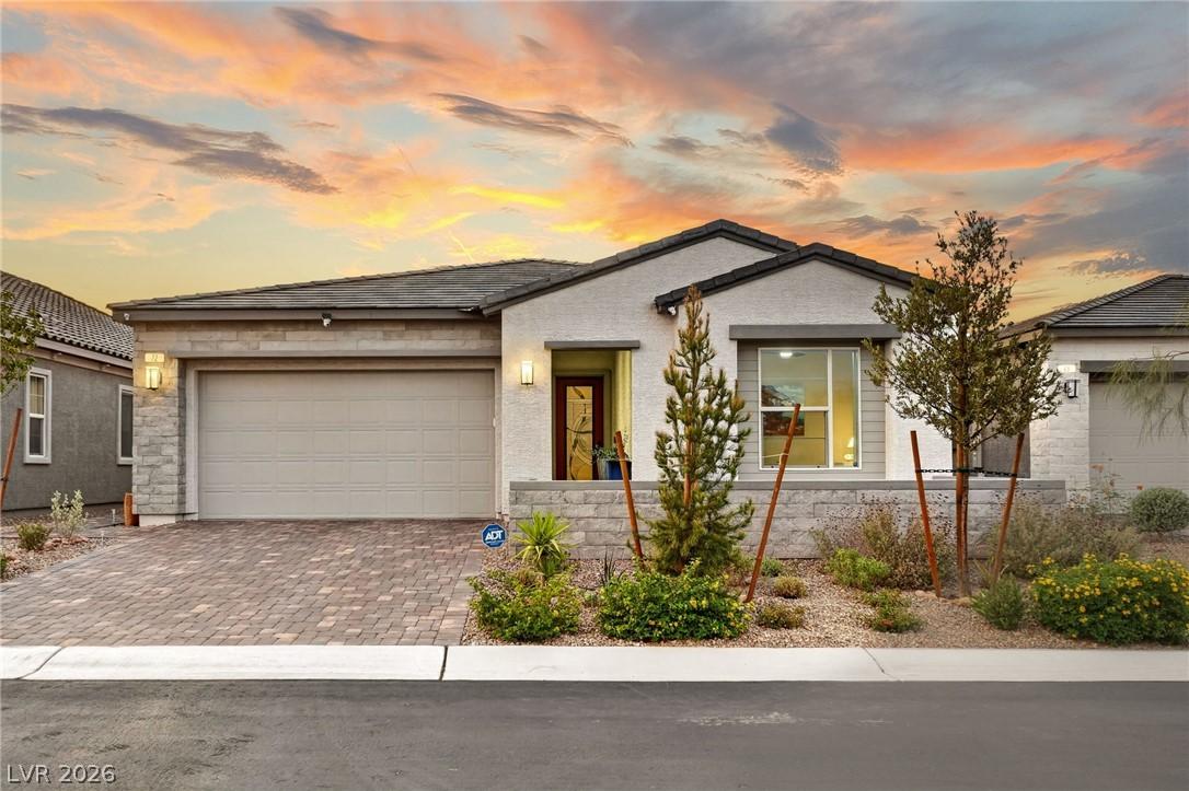 Image 1: A well-maintained single-story home with a paver d