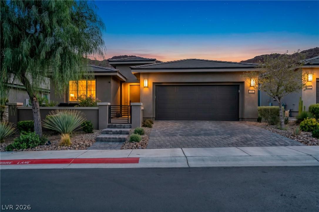 Image 1: This desert-adapted home welcomes with a paver dri