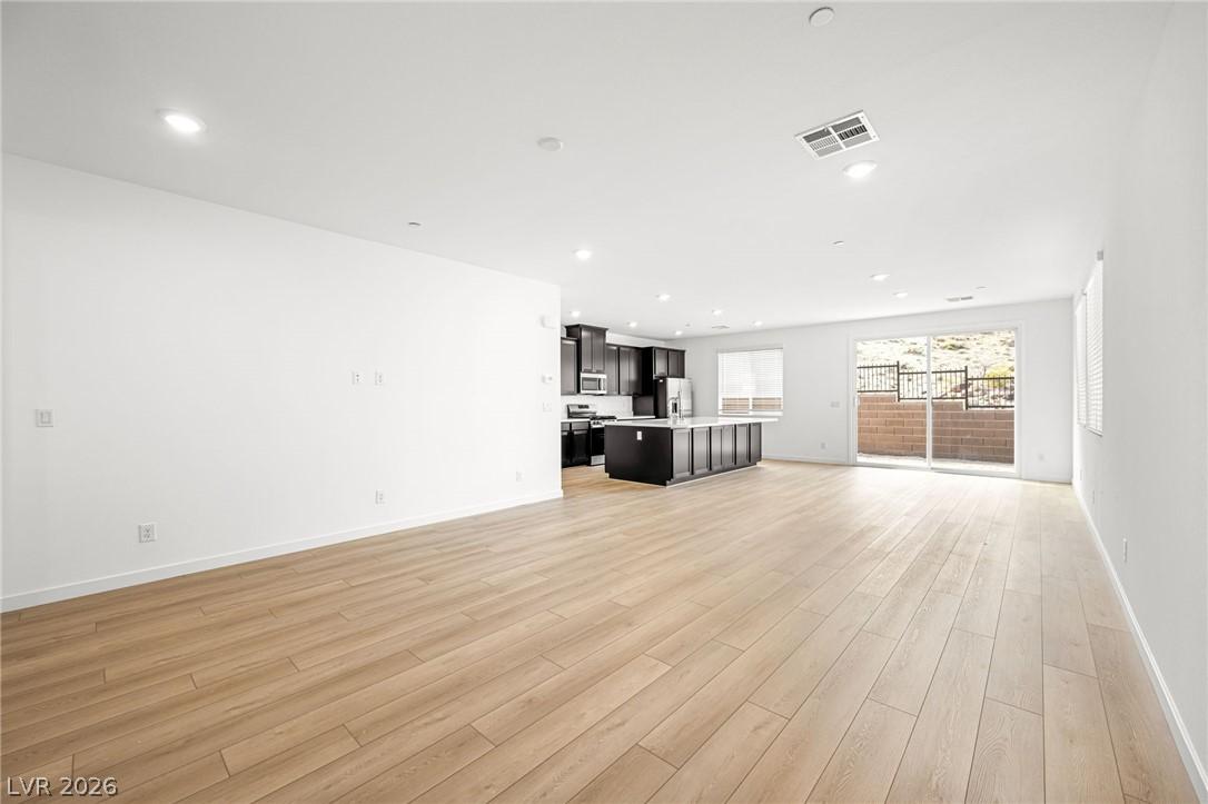 Image 3: An open-concept living space presents light-toned