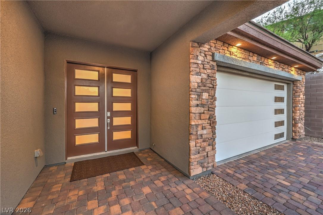 Image 4: A modern facade with a paneled entry door and a ga