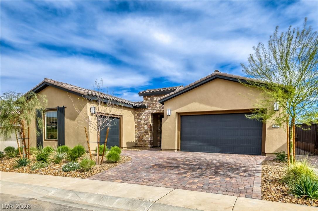 Image 4: A charming stucco home welcomes with a paver drive
