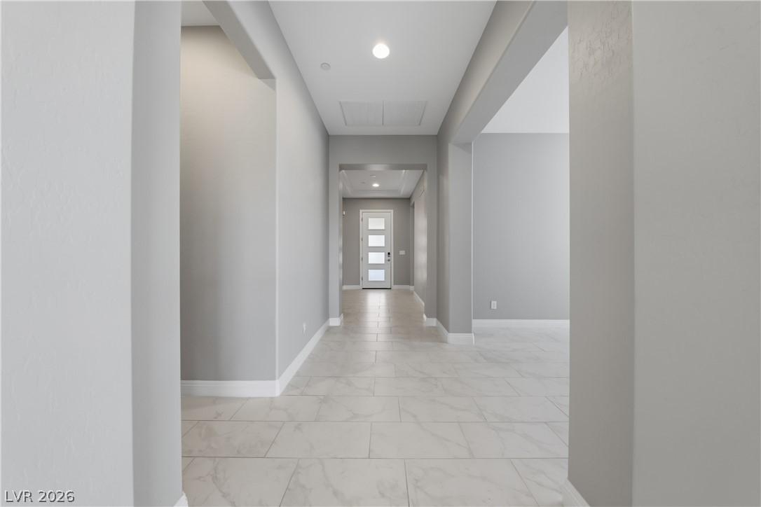 Image 4: A well-lit entryway features a modern front door a