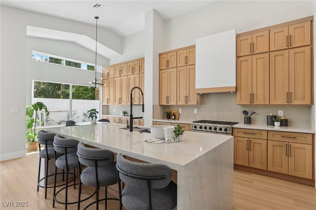 Image 1: Kitchen featuring decorative backsplash, light sto