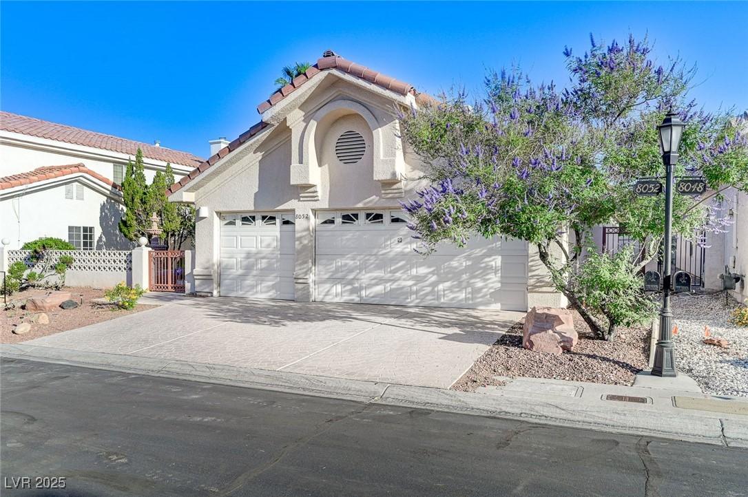 Image 3: View of front of home with a tiled roof, stucco si