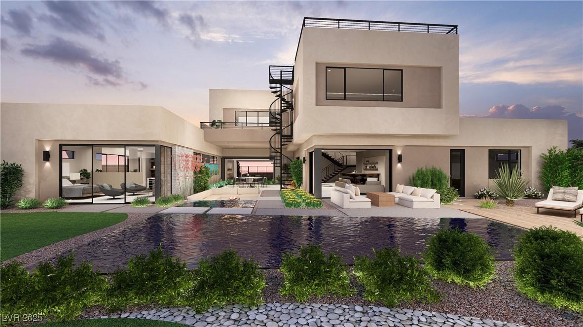 Image 4: Back of house at dusk featuring outdoor lounge are