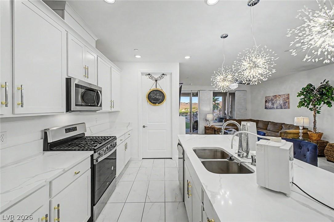 Image 4: A chef's kitchen boasts white cabinetry, a gas ran