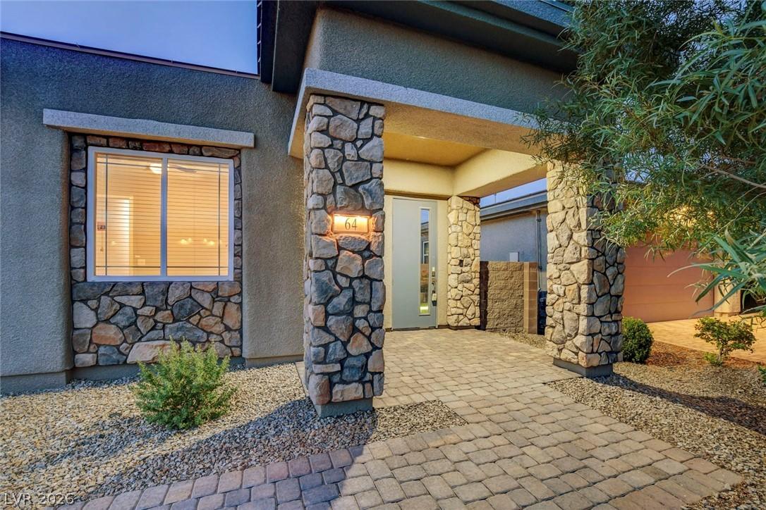 Image 4: This home features a stone facade and a paver walk