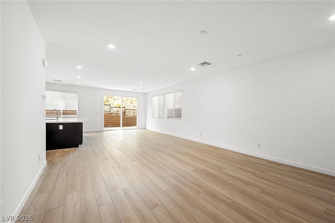 Image 4: An airy great room featuring light wood flooring a