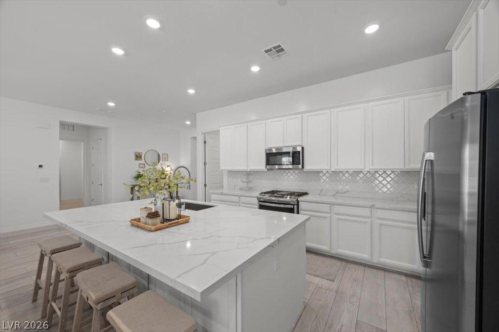 Image 2: A luminous kitchen features crisp white cabinetry