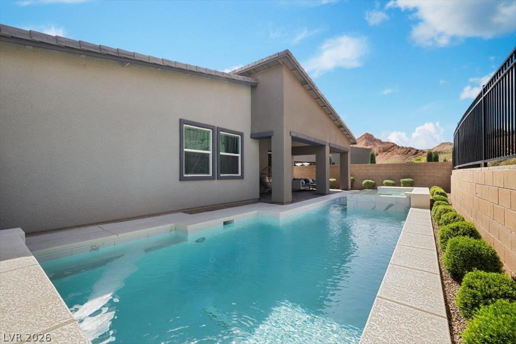 Image 4: An inviting backyard oasis offers a sparkling pool